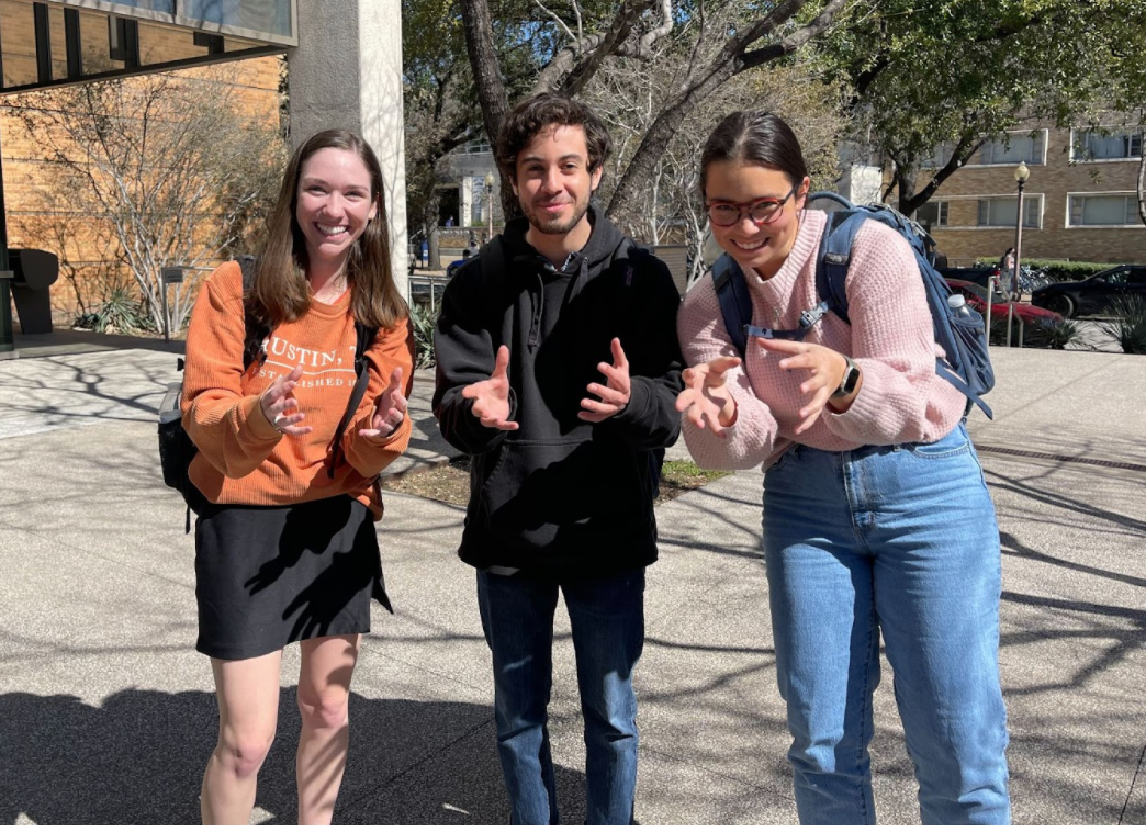 Three students stand together outside