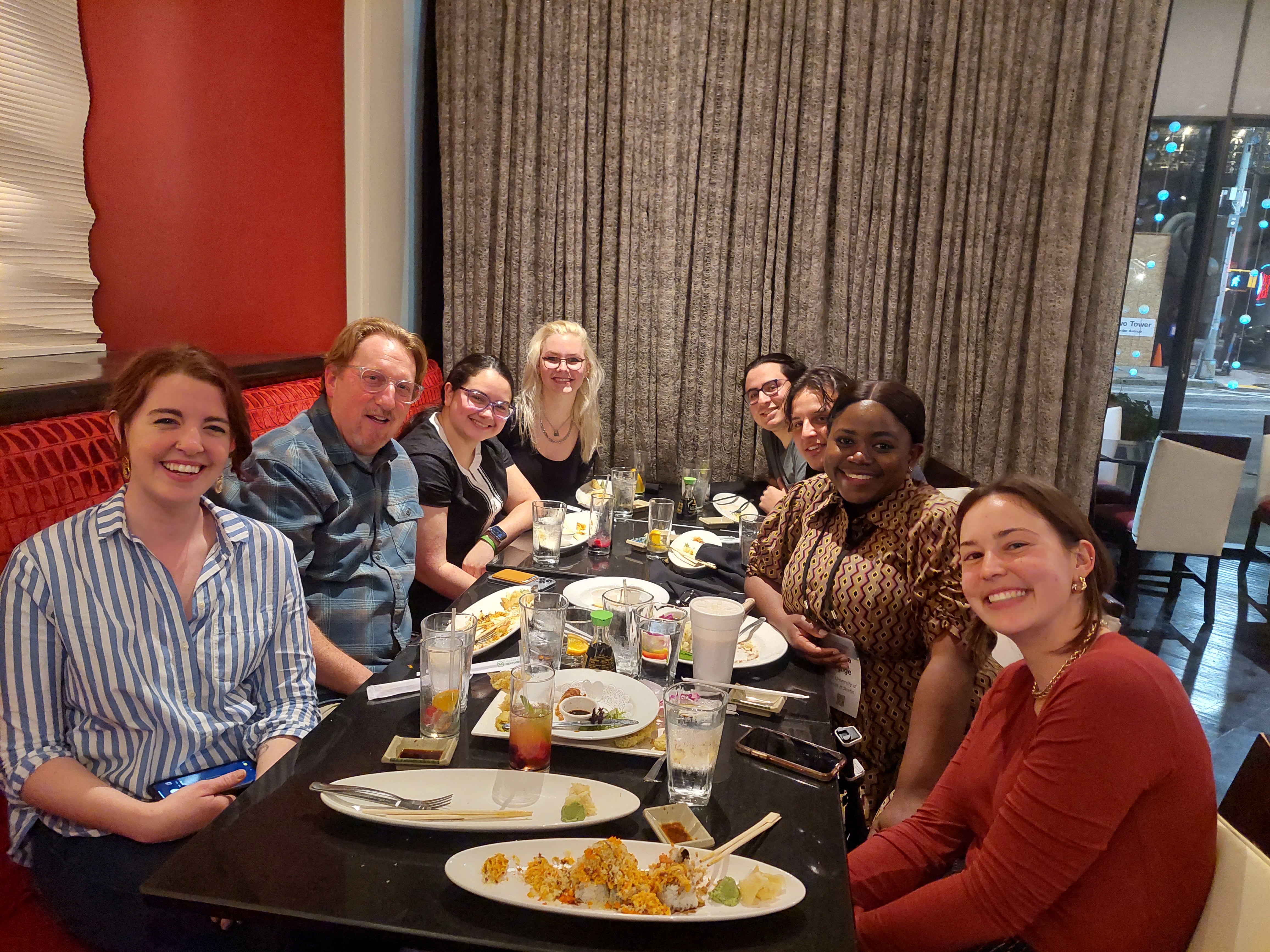 Students sit around dinner table with professor