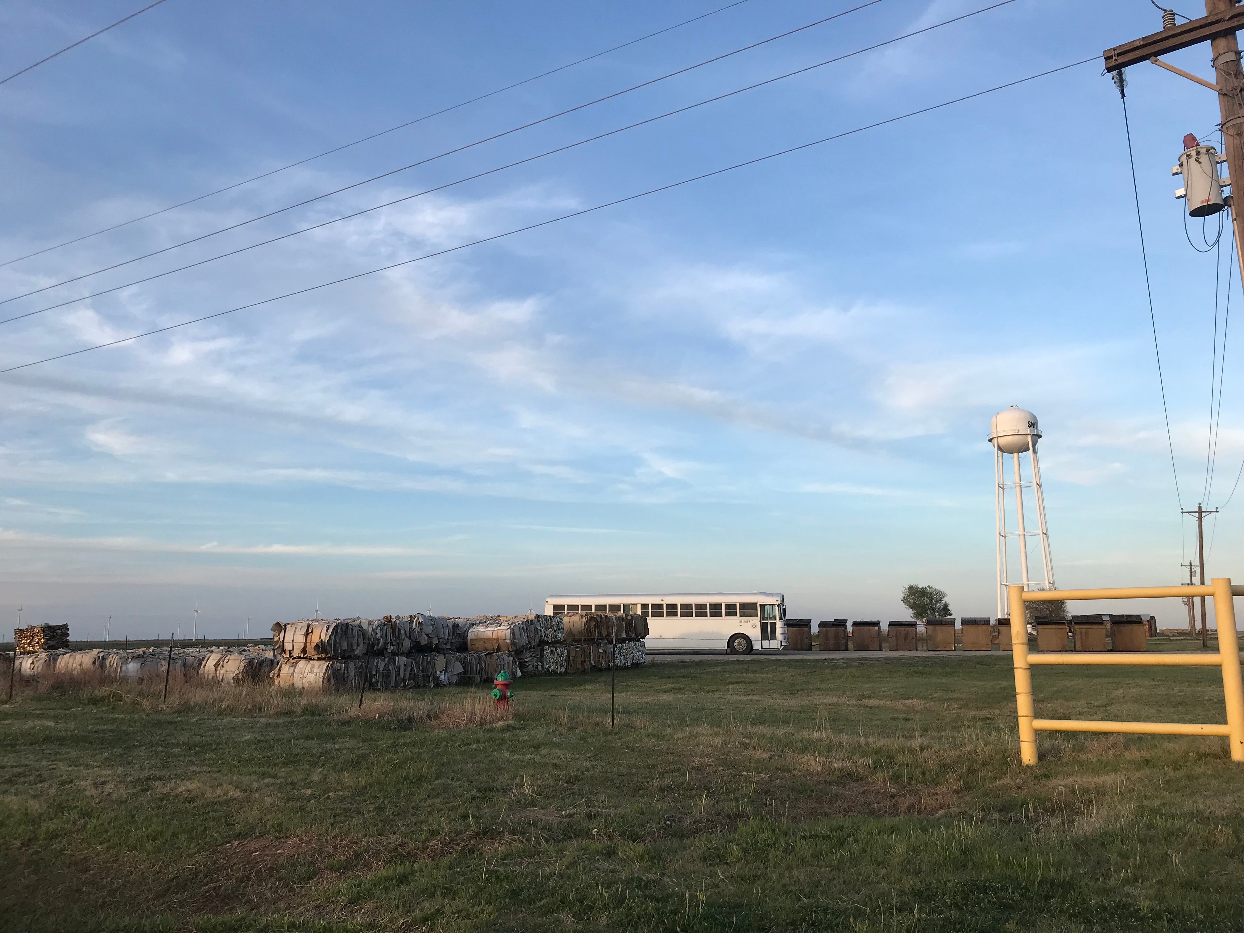 A photograph of West Texas / Hay bales by a bus