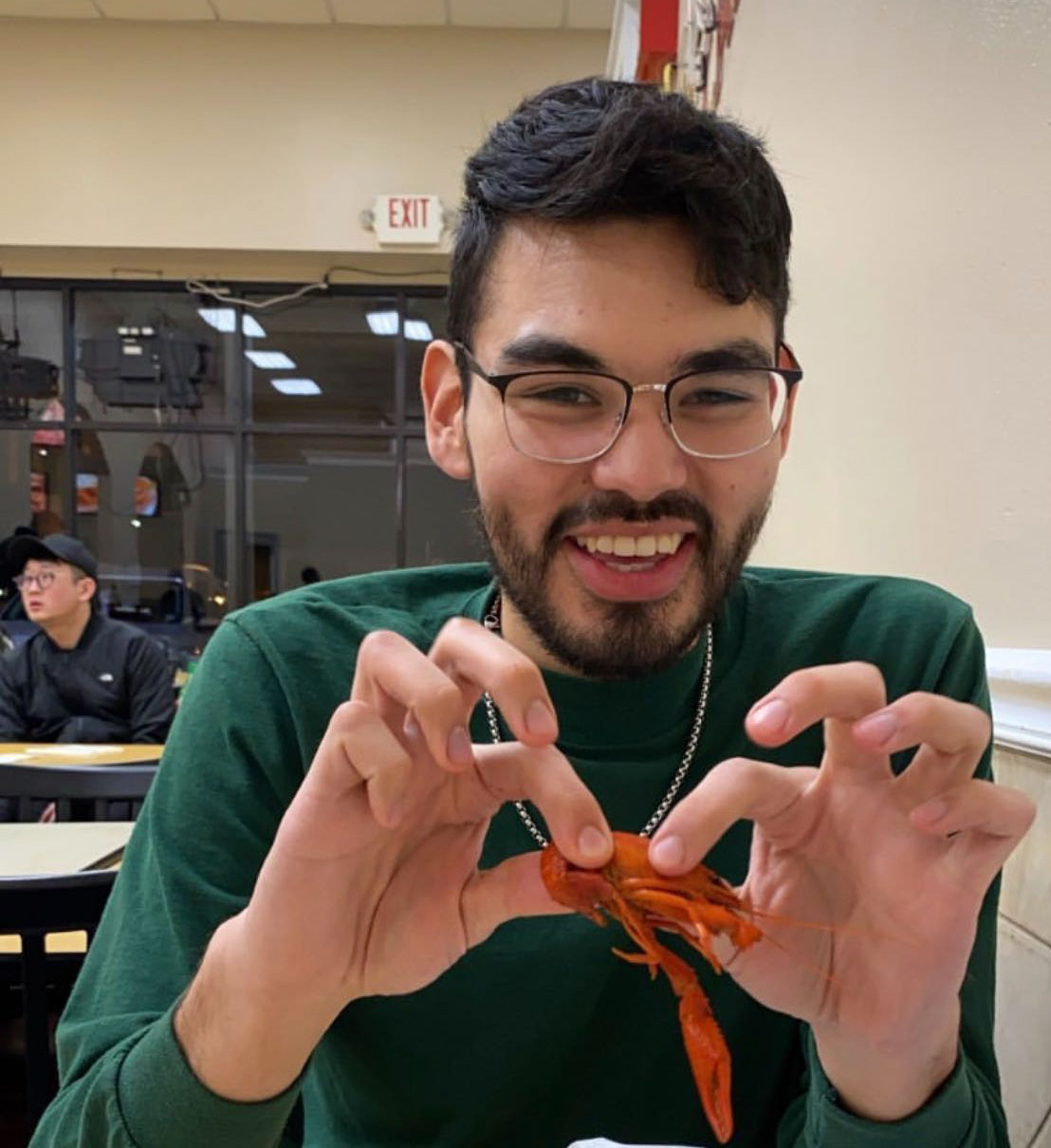 Student Rolando Hernandez poses with a crawfish 