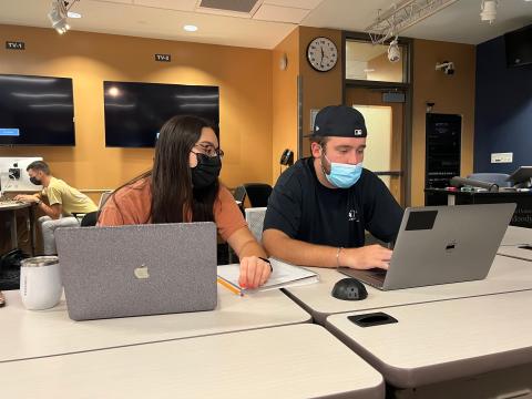 Two students looking at a laptop