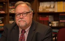 Headshot of Don Heider with library in background
