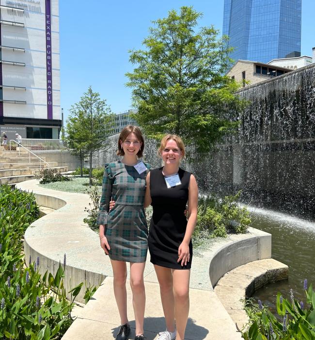 two students standing in front of fountain