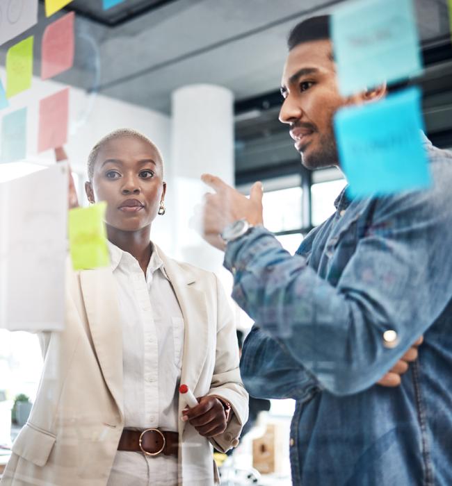 two professionals brainstorming with post-it notes