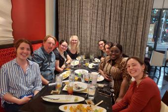 Students sit around dinner table with professor
